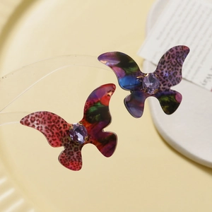 Macro view of gradient leopard butterfly charm with central purple gemstone accent