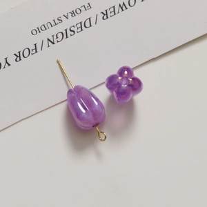 Detail of purple tulip pendant and floral acrylic beads with iridescent finish