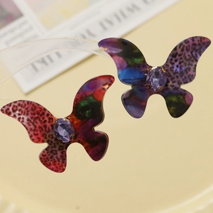 Macro shot of gradient leopard acetate butterfly pendant with purple gemstone inlay
