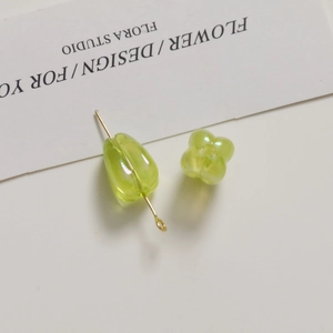 Macro shot of translucent light green tulip flower and teardrop acrylic beads for DIY jewelry