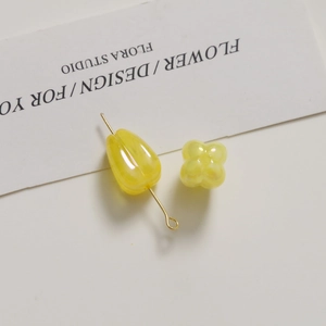 Macro shot of yellow tulip leaf acrylic beads with gold pin for DIY jewelry crafts