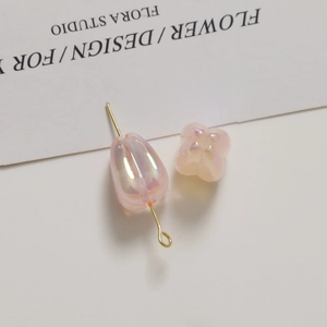 Macro view of translucent pink tulip and leaf acrylic beads with AB iridescent finish