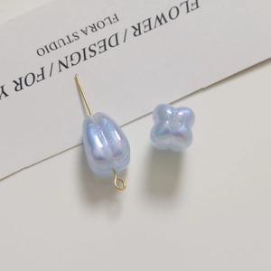Macro view of light blue pearlescent tulip and flower charms for DIY jewelry making