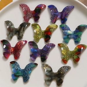Detailed view of colorful gradient acetate butterfly charms with leopard patterns