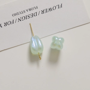 Macro detail of pearlescent tulip charms and teardrop beads for DIY jewelry design