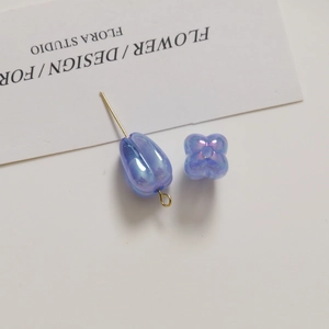Detail view of iridescent light blue tulip beads and petal charms for DIY jewelry