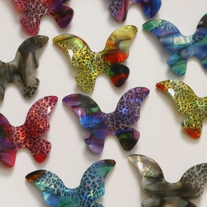 Flat lay of gradient leopard print acetate butterfly charms for DIY jewelry making