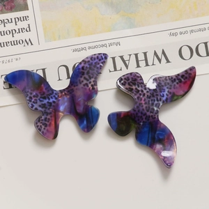 Macro detail of gradient leopard print acetate butterfly charms for jewelry making