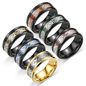 Close-up of stainless steel Celtic dragon inlay rings in black and gold finishes