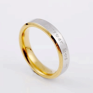 Detalle macro del anillo bicolor de acero inoxidable grabado con Forever Love y corazones