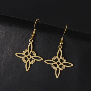 Detail von goldenen keltischen Knoten-Ohrringen auf schwarzem Lederhintergrund
