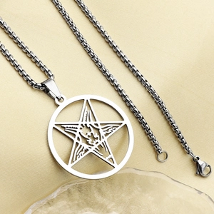 Macro detail of silver stainless steel hollow circular pendant with engraved pentagram star