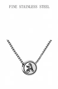 Detailed macro view of silver stainless steel pendant featuring a Gothic letter A