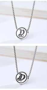 Macro detail of silver titanium steel necklace with a gothic engraved letter D pendant