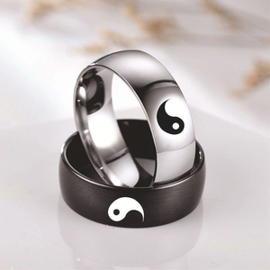 Macro shot of yin yang couple rings in polished silver and matte black stainless steel