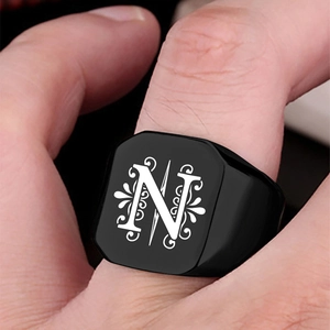 Macro shot of black stainless steel signet ring with letter N and floral engraving