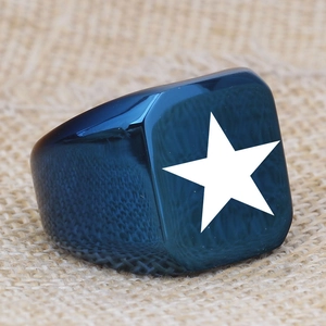 Close-up of a blue polished signet ring with a white star on a burlap surface