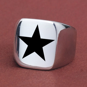 Close-up of a wide silver stainless steel ring featuring a black star on a square face