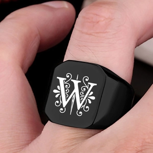 Macro shot of men's black stainless steel ring featuring engraved letter W with scrolls