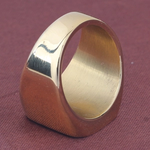 Close-up of polished golden stainless steel signet ring with smooth flat surface