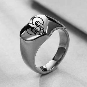 Macro shot of silver heart signet ring with engraved family portraits for parents