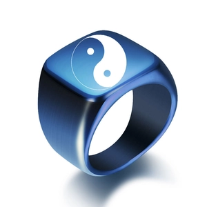 Detail of blue titanium steel ring with Yin Yang symbol and brushed metal texture