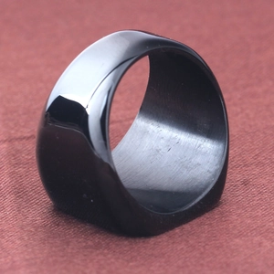 Macro shot of wide black stainless steel ring showing smooth mirror surface and matte interior