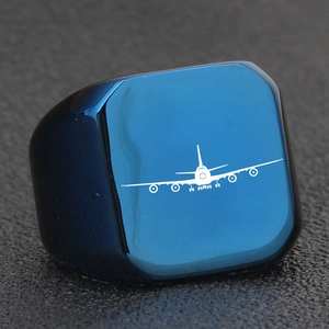 Dettaglio macro dell'anello quadrato in acciaio al titanio blu con icona aereo bianco e spazzolato
