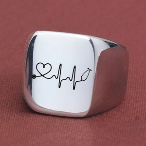 Detailed macro shot of silver square signet ring with engraved heartbeat EKG medical pattern