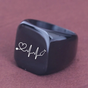 Macro detail of black stainless steel ring with white EKG and stethoscope pattern