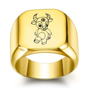 Close-up of golden zodiac ring with engraved cartoon ox design on square flat top