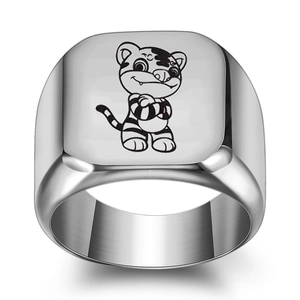 Macro shot of silver signet ring featuring a cartoon tiger engraving and brushed metal texture