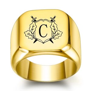 Macro shot of gold signet ring featuring square face with engraved swords and letter C