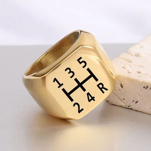Dettaglio macro dell'anello a sigillo dorato con motivo a 5 marce stile cambio auto