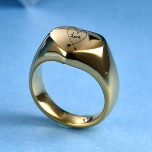 Vista detallada de un anillo de sello de corazón en acero dorado 18K con grabado Love