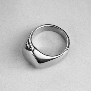 Vista macro de un anillo de sello ancho en acero inoxidable pulido con cara rectangular