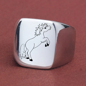 Macro shot of silver square signet ring with engraved black horse icon on top surface