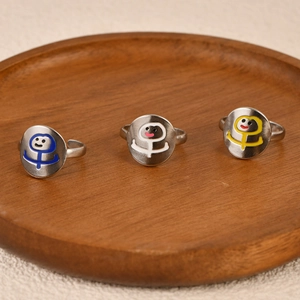 Three minimalist silver stainless steel open rings with colorful cartoon face designs