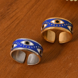 Retro evil eye open rings in gold and silver finish with blue enamel details on wood