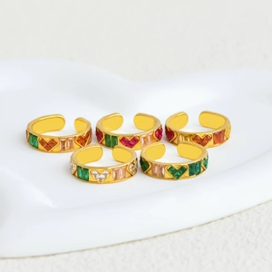 Set of five gold plated open rings with colorful heart shaped zircons on a white tray