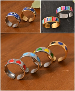 Detail of gold-plated open rings with colorful enamel patterns and zircon accents