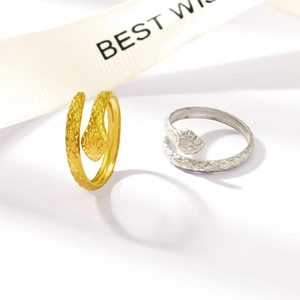 Detailed view of gold and silver snake rings with scale texture and adjustable bands