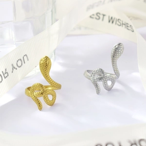 Detail shot of gold and silver snake rings with intricate scale texture and open band design