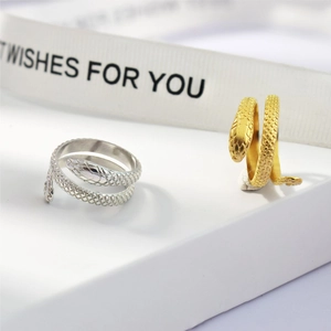 Detailed view of silver and gold snake rings with scale textures on white platforms