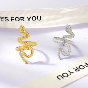 Detail of snake-shaped adjustable rings with textured scale finish in gold and silver