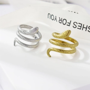 Close-up detail of gold and silver snake coil rings with realistic scale texture engraving