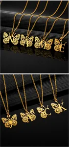 Détail du pendentif papillon doré ajouré avec lettre initiale sur fine chaîne croisée