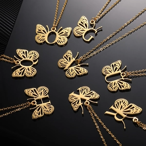 Vue détaillée des pendentifs ailes de papillon dorés avec diverses lettres de l'alphabet