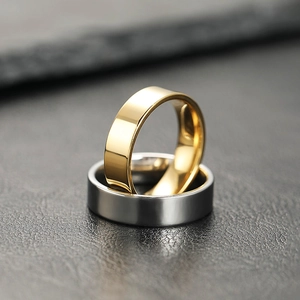 Macro shot of polished gold and silver stainless steel rings on a dark leather surface