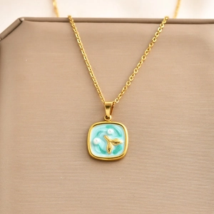 Elegante collana in titanio dorato con ciondolo quadrato e coda di sirena blu e perla